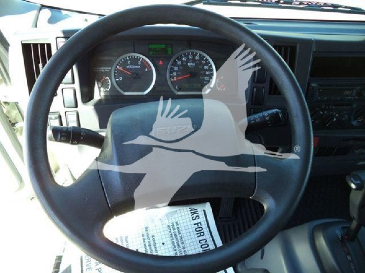 Isuzu NPR interior dashboard and steering wheel view showing gauges and controls.