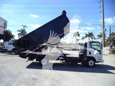 Isuzu NPR dump truck with bed raised showing cargo area and cab, side view.