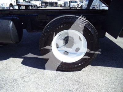 Isuzu NPR wheel and tire view showing white steel wheel and tire with surrounding undercarriage components.