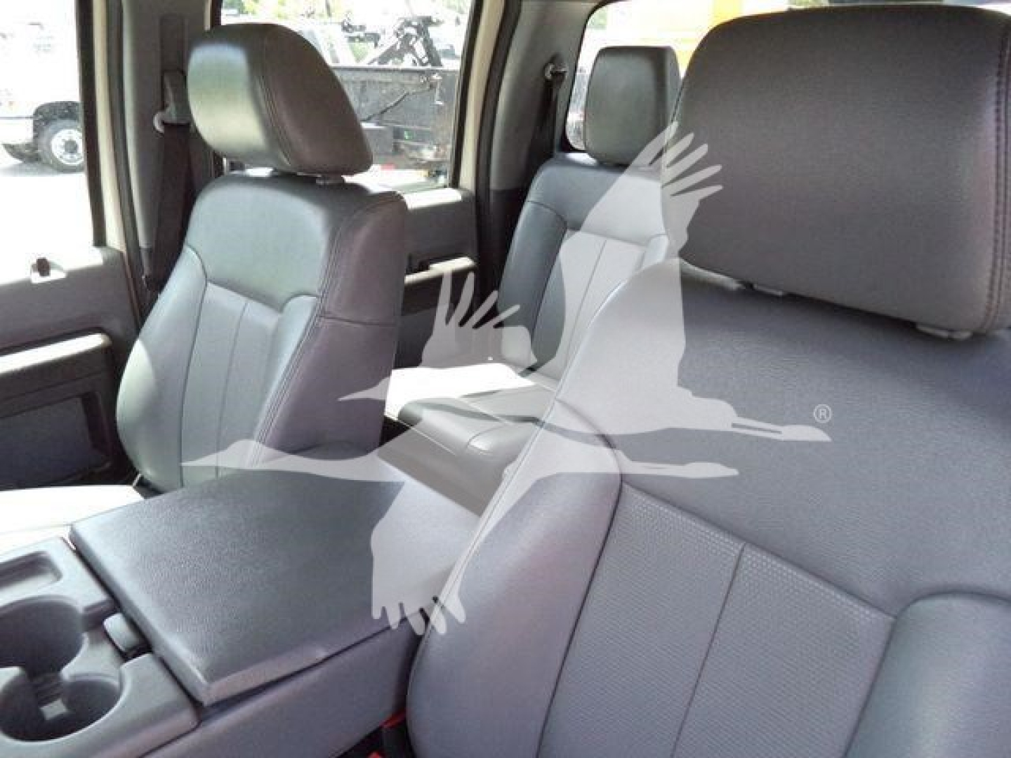 Interior front seats of a 2016 Ford F550 truck showing gray fabric seats and center console.