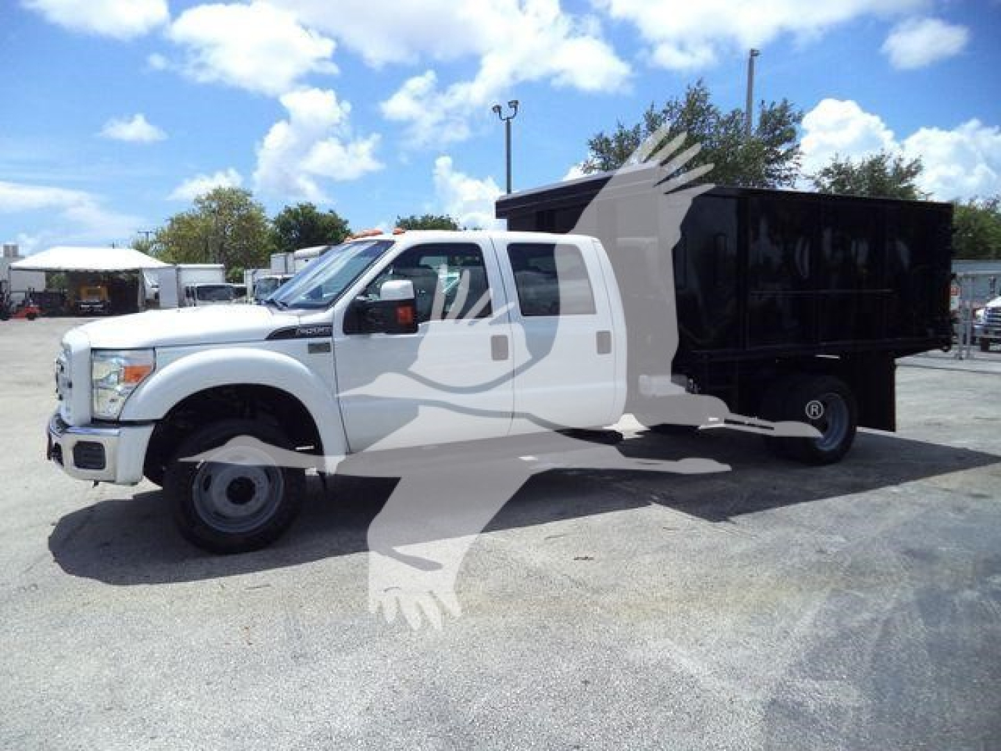 Ford F-550 dump truck with white cab and black dump bed, side view showing extended cab and hydraulic system