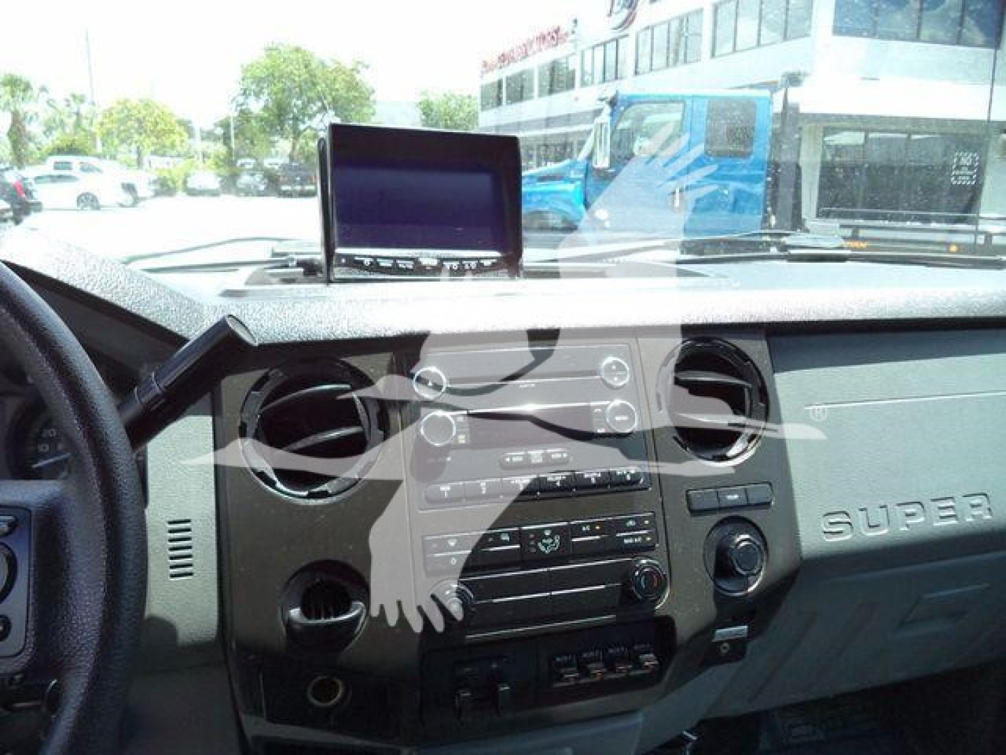 Dashboard view of a 2016 Ford F-550 dump truck interior showing center console, steering wheel, and a mounted tablet on the dash.