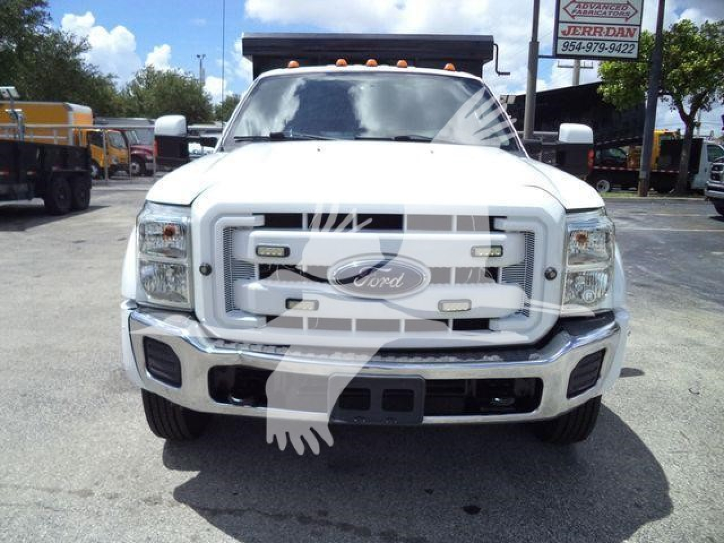 Front view of a white 2016 Ford F-550 dump truck with chrome grille, Ford emblem, two rectangular headlights, and a black dump bed topper visible in background.