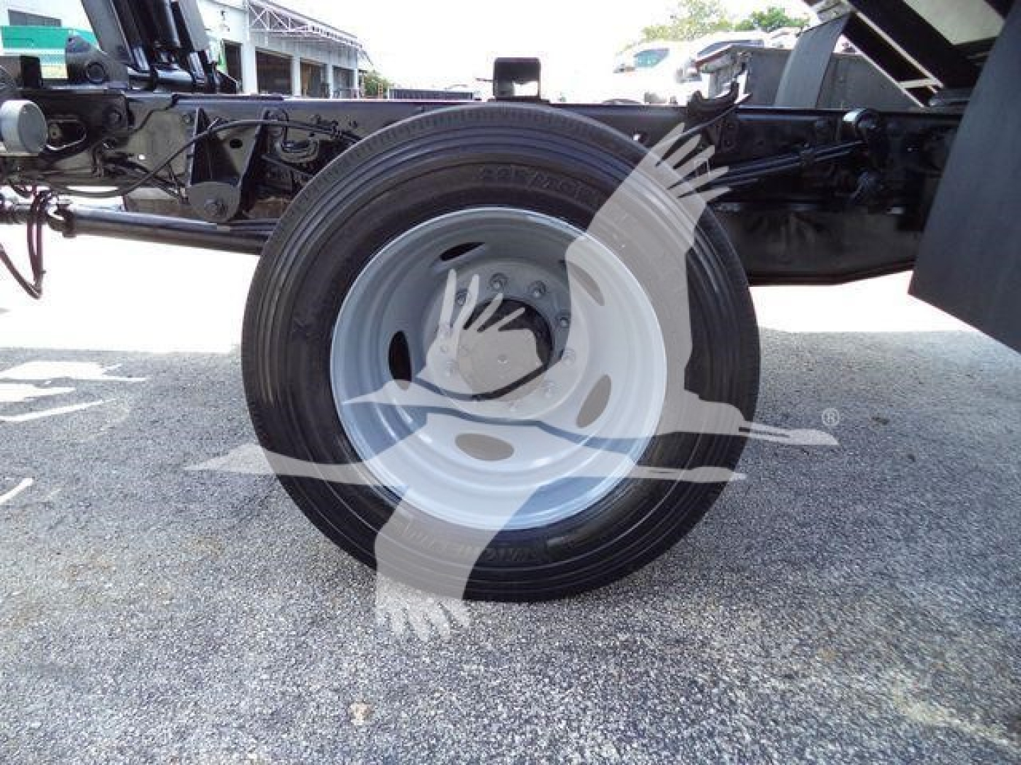Single rear wheel of a 2016 Ford F550 dump truck chassis showing white steel rim and black tire with surrounding undercarriage components.