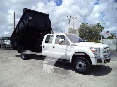 2016 Ford F550 dump truck with a raised black dump bed, white cab, side view showing dual rear wheels and long cab.