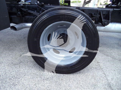 Ford F550 chassis with single rear wheel showing tire and wheel assembly under a dump truck frame.