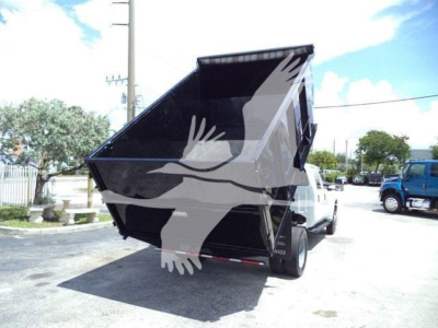 Ford F-550 dump truck rear view with raised dump bed showing the inside and rear wheels.