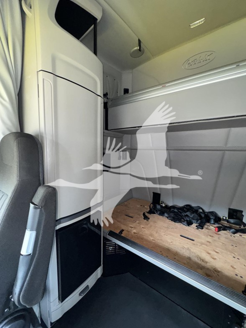 Peterbilt 579 cab interior showing sleeper bunk and overhead storage with visible plywood floor and scattered tools.
