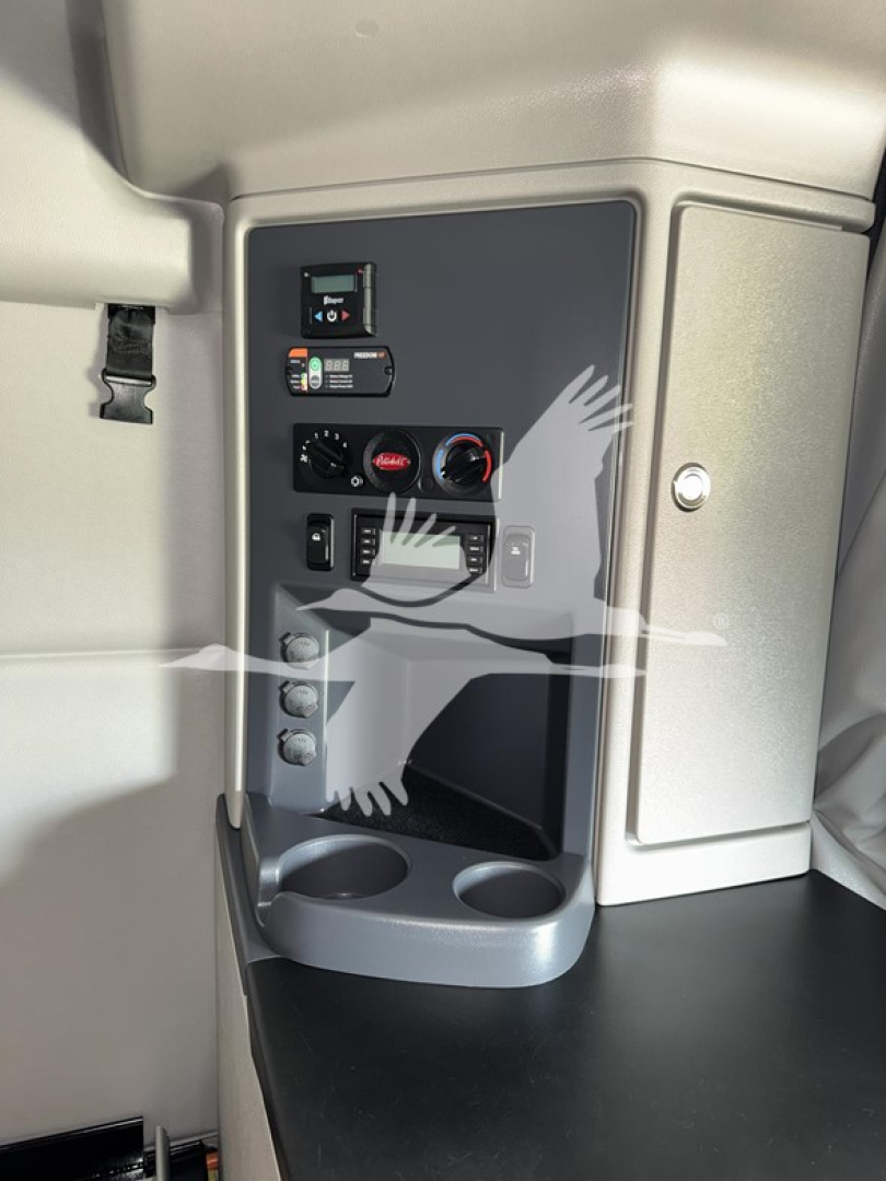 Peterbilt 579 cab interior panel showing controls and cup holder area.