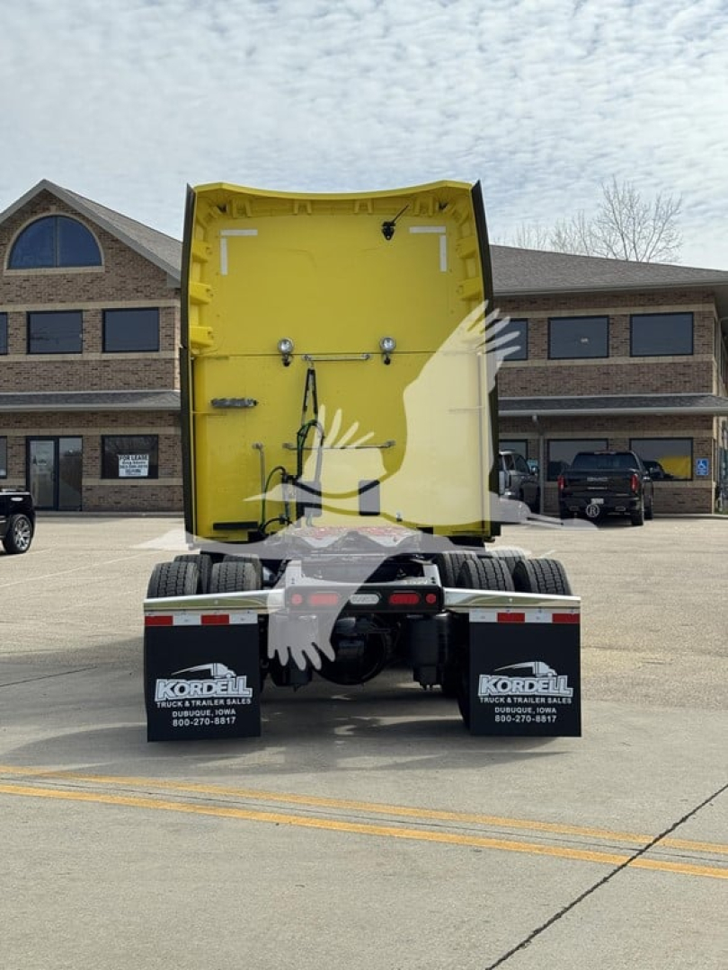 Peterbilt 579 tractor rear view with yellow sleeper cab interior, visible rear mud flaps and chassis.