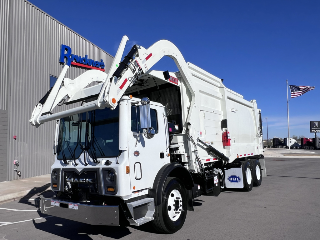 Truck mounted WAutomatic arm and rear hopper truck in serviceable condition showing Mack TE64 garbage truck with hydraulic arm and crane, white exterior.