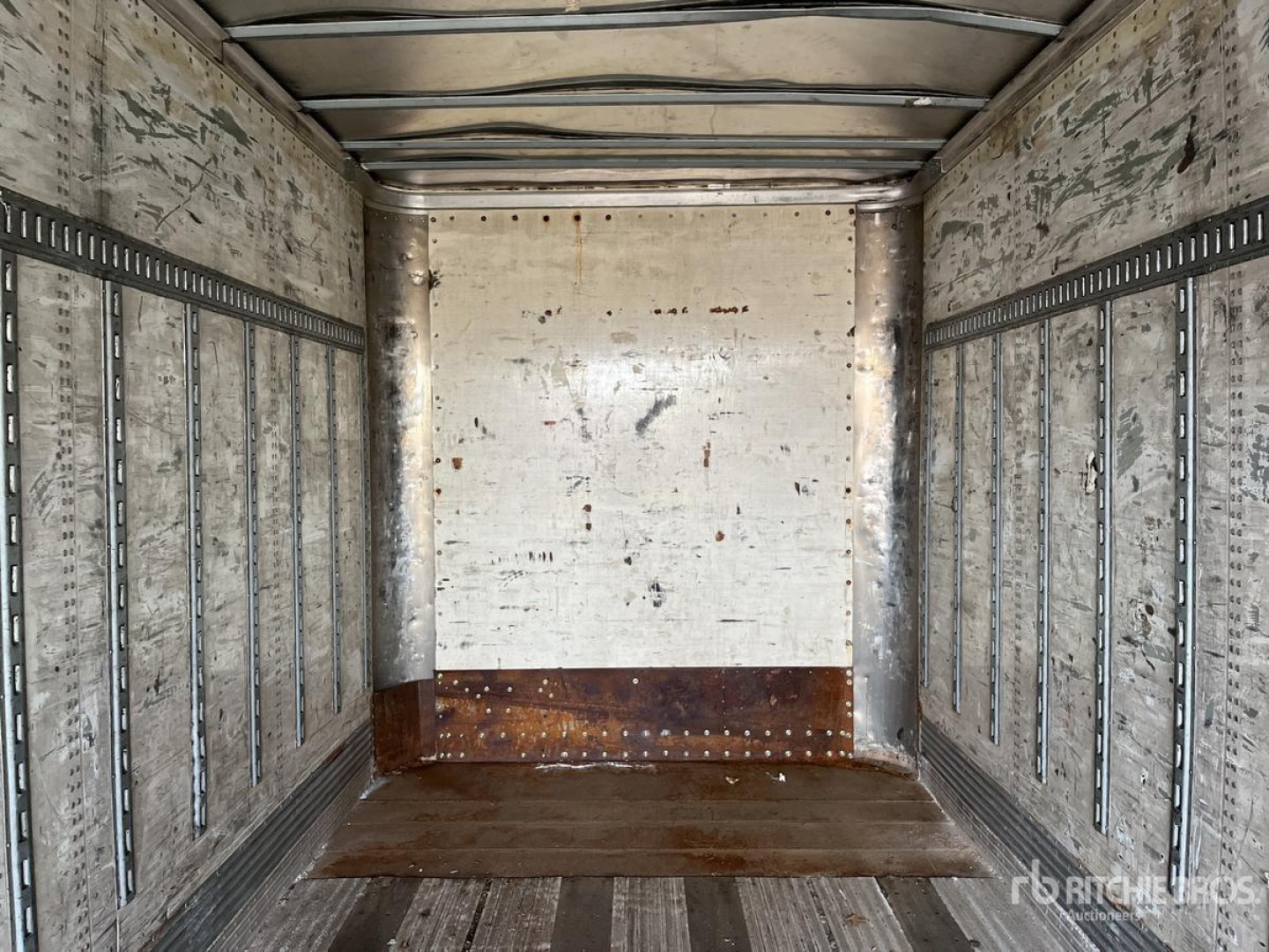Trailer interior showing empty cargo area with metal side rails and wooden floor in a 2004 Wabash DVDBHPC trailer.