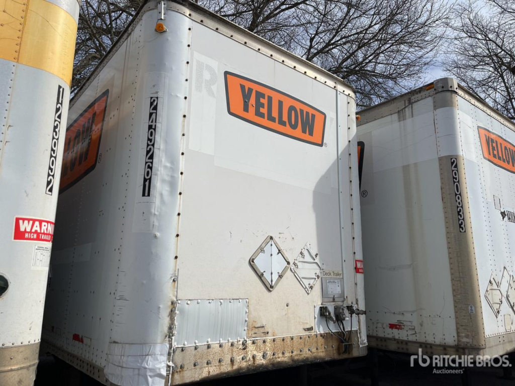 Trailer rear doors with YELLOW label on a Wabash DVDBHPC trailer in a lot, with another trailer beside it.