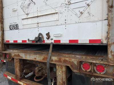 Rear view of a used van trailer with a ramp/slide door, visible rust on frame, taillights, and safety chains; stock number 249261 and deck trailer label.