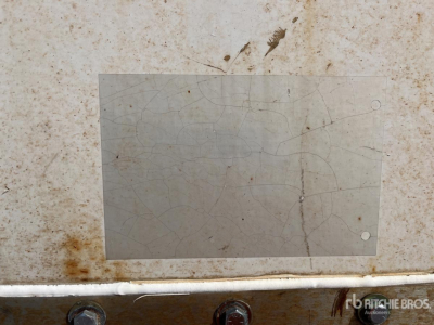 Vehicle trailer identification plate area showing wear with a blank grey metal plate and small rust spot.