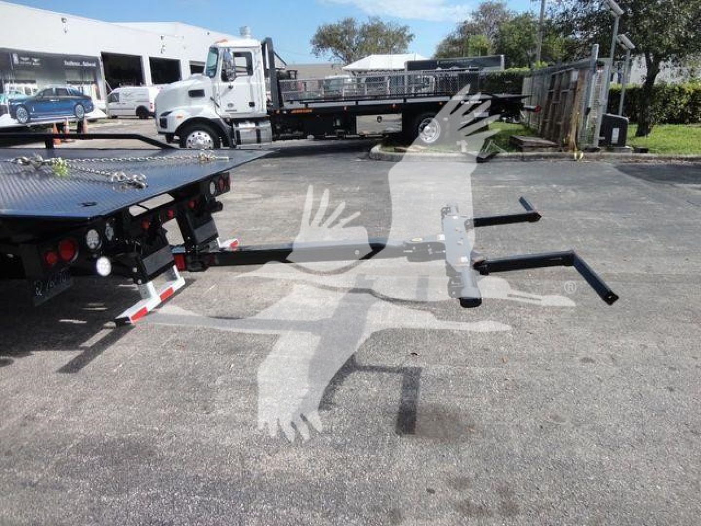 MD6 truck roll-back equipment with flatbed and towing arms visible in lot.