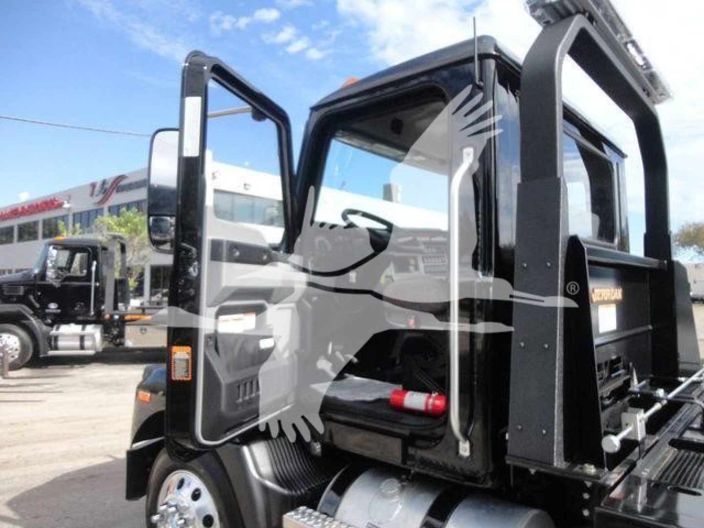 2026 Mack MD6 cab with open door showing interior and Rollback equipment; visible text includes stock/advertising items on the truck but no legible model details beyond MD6 and Mack branding.