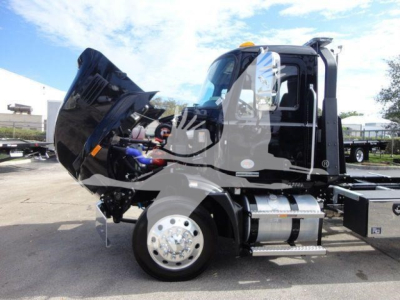 MD6 bumper hood open showing Mack 6-series cab with chrome fuel tank and wheel, rollback truck chassis in daylight