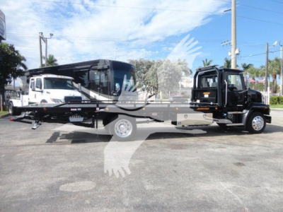 MD6 rollback truck on flatbed with tow truck-style cab and autogrip branding visible.