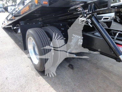 Mack MD6 rollback truck chassis showing dual rear wheels and hydraulic system undercarriage with black metal framing and stickers.