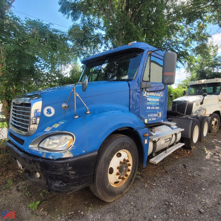 Blue Freightliner Columbia 120 daycab truck side view showing front grille, dual mirrors, fuel tanks, and wheels; part-identification text on door and bumper area.