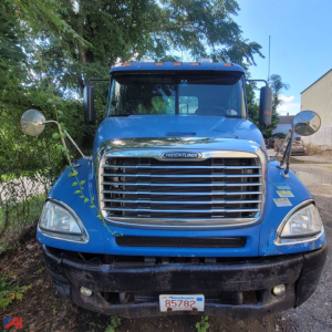 Front view of a blue 2006 Freightliner Columbia 120 conventional truck showing chrome grille, large bumper, round mirrors, and Minnesota plate 85782.