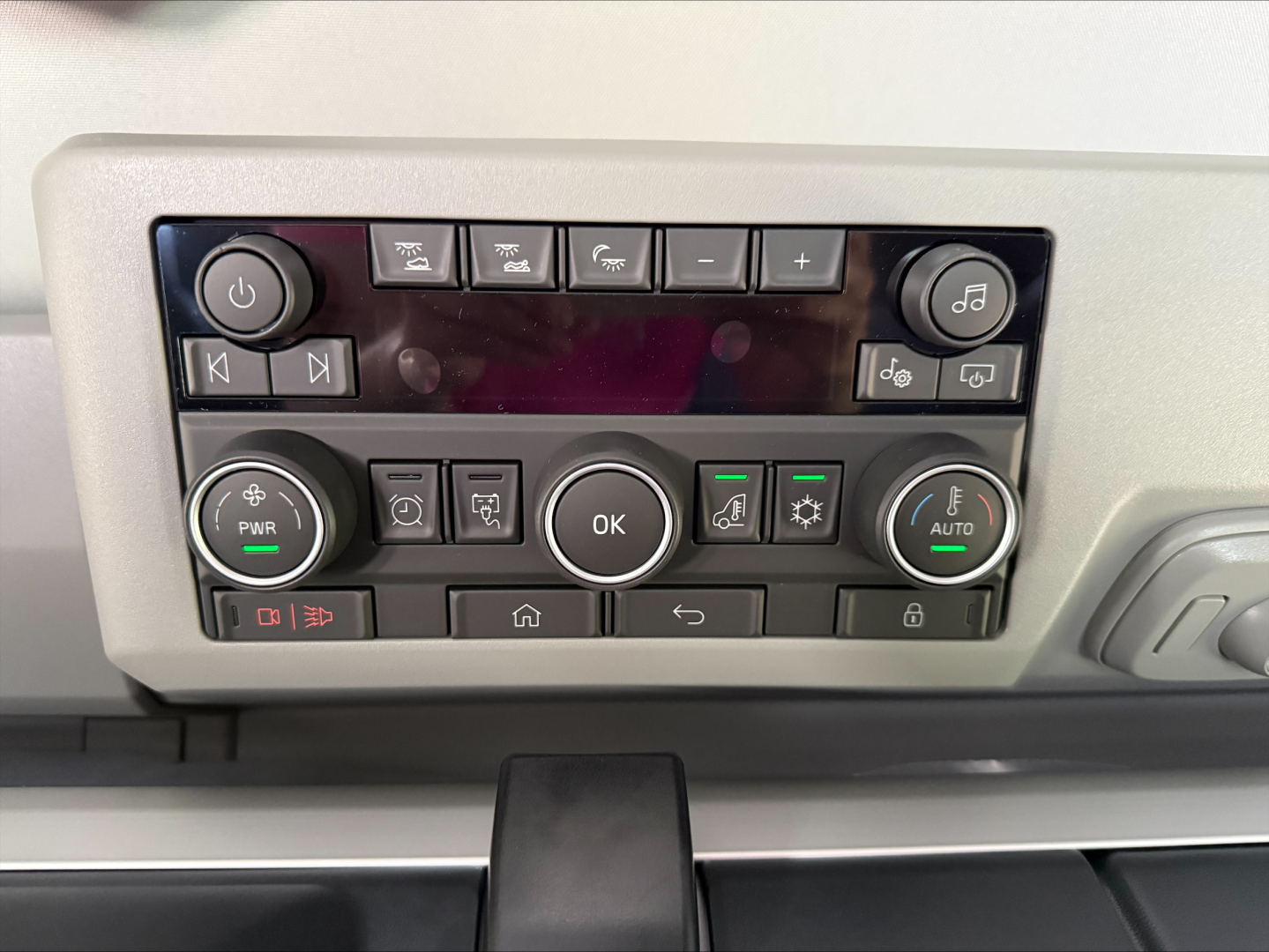 Volvo VNL64T860 dashboard panel showing control buttons and knobs in gray housing.