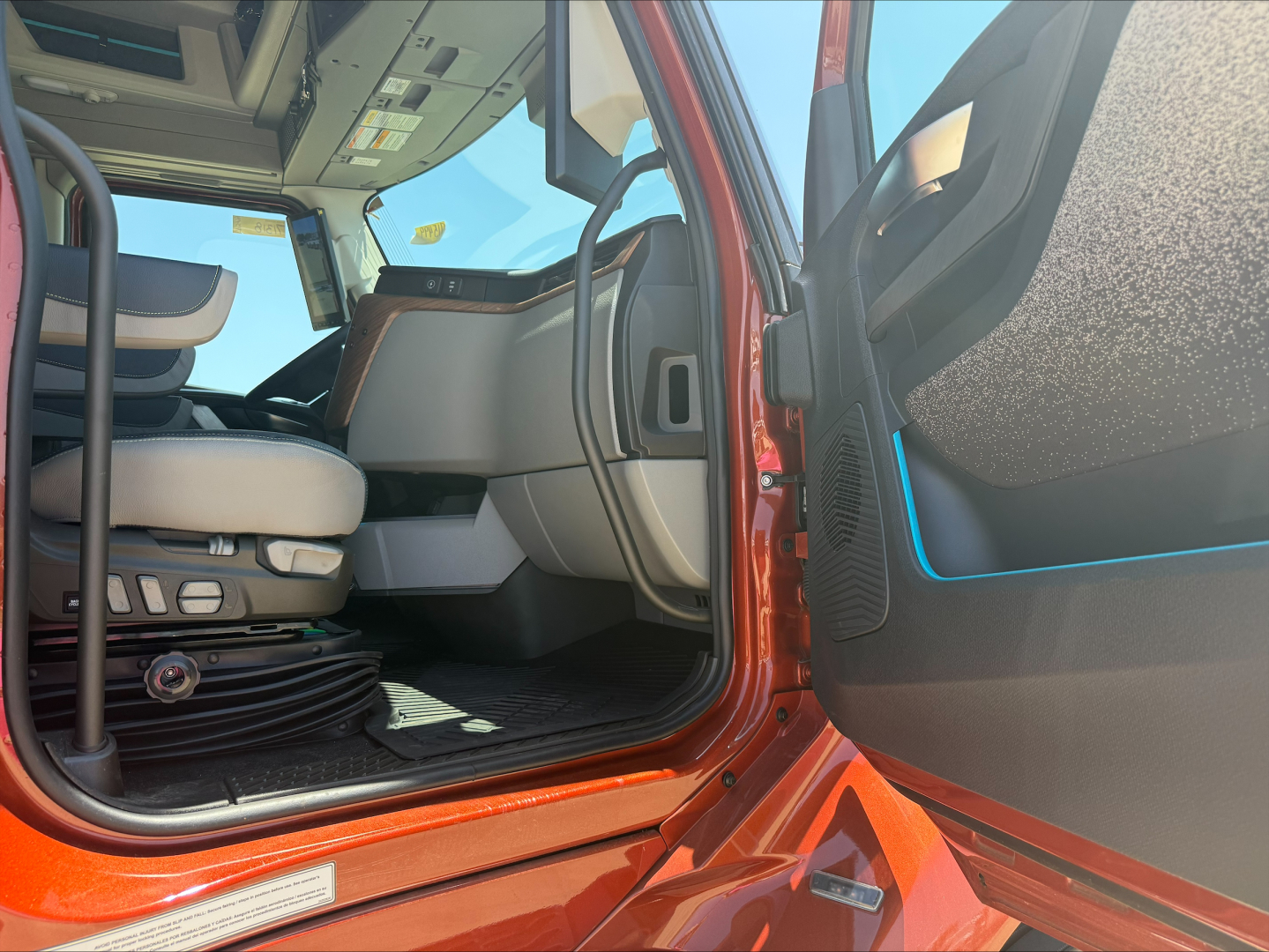 Volvo VNL64T860 truck interior and openDoor showing driver seat, cabin controls, and entry area.