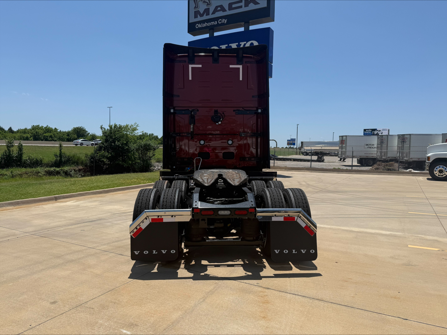 Volvo VNL64T860 (rear view) truck shown in a dealership lot, with rear dual wheels, fender mudflaps labeled VOLVO, and a high sleeper cab.