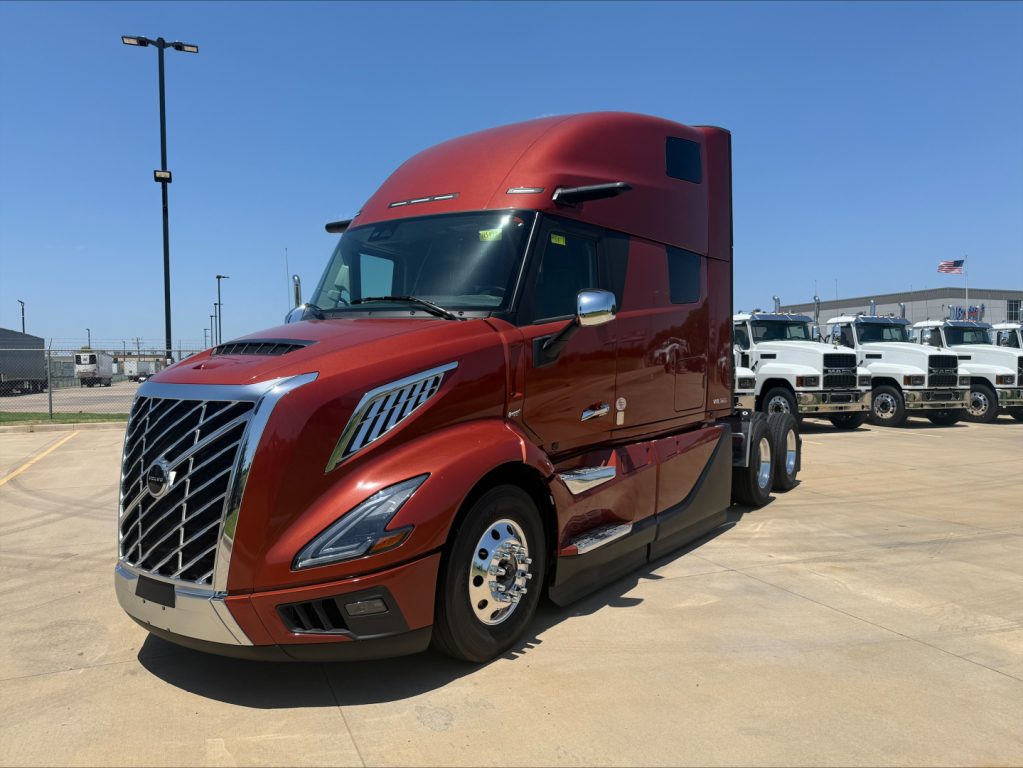 Volvo VNL64T860 sleeper cab tractor in red showing front grille, headlights, and side view with chrome wheels.