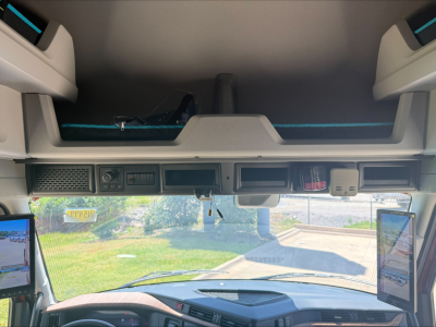Volvo VNL64T860 dash area showing dual 7-inch screens and overhead storage with windshield and dashboard view