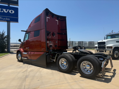 Volvo VNL64T860 tractor cab and rear axle chassis with red cab, dual rear wheels, and trailer hitch area visible.