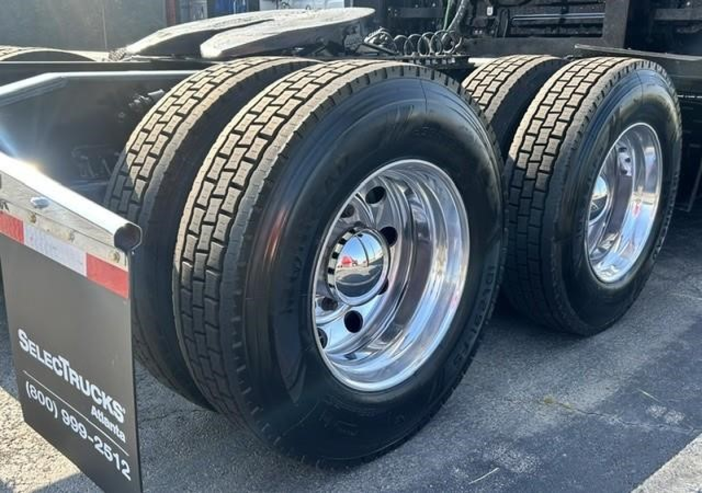 Freightliner Cascadia 126 wheels and dual rear axles with polished rims visible.