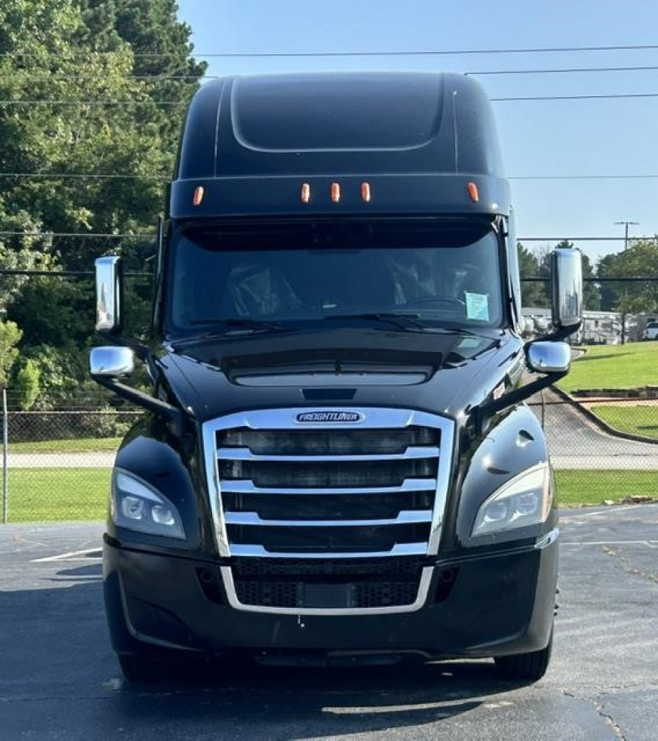 Truck front view of a 2022 Freightliner Cascadia 126 with black exterior and chrome grille, headlights, and mirrors visible.