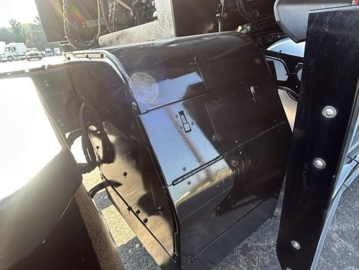 Freightliner Cascadia 126 engine bay side panel showing metal access door and black painted surfaces.