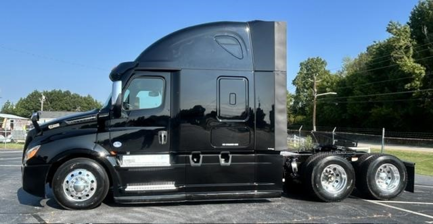 Conventional sleeper truck side view showing Freightliner Cascadia 126 with black paint and dual rear axles.