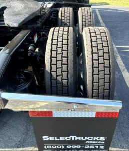 Freightliner Cascadia 126 rear wheel quad setup showing dual rear axles and part of trailer bumper with SelecTrucks Atlanta logo