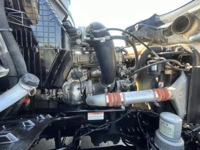 Cascadia engine bay showing intercooler piping, turbocharger, coolant reservoir cap, and various hoses; label stickers visible on components.