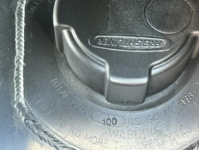 Front engine bay area of a Freightliner Cascadia 126 showing a fill cap with 'GENUINE' branding and circular warning text around the cap.