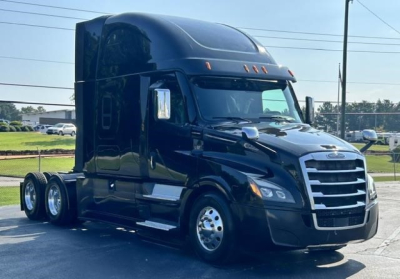 Truck side view showing a black 2022 Freightliner Cascadia 126 highway tractor with sleeper cab, chrome grille, and dual rear axles.