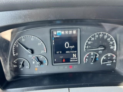 Dashboard display of a Freightliner Cascadia truck showing speed 0 mph on central digital screen, with gauges for fuel, oil, and coolant, and warning icons.