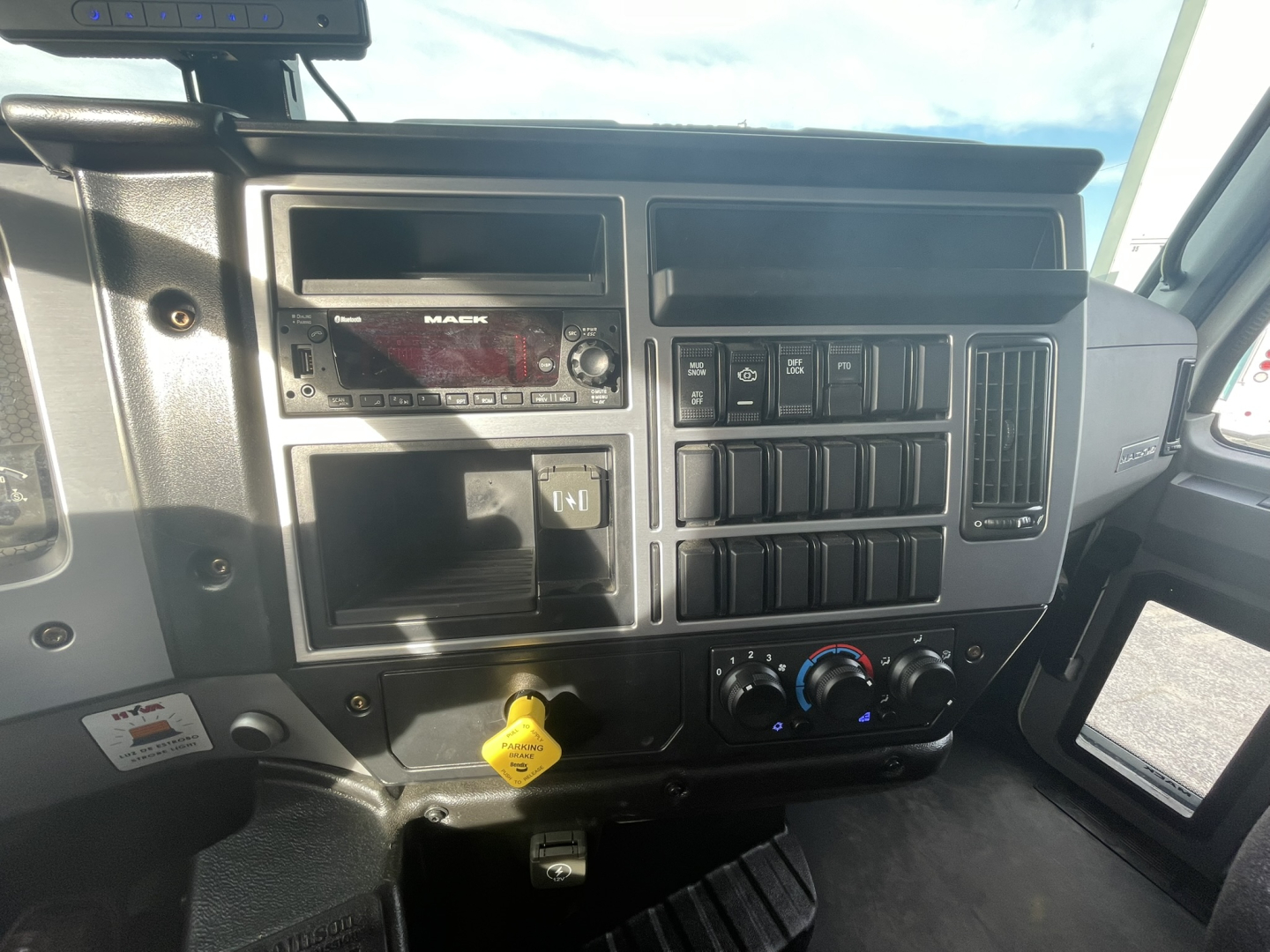 Mack MD7 truck cab dashboard showing radio, control switches, and climate dials.