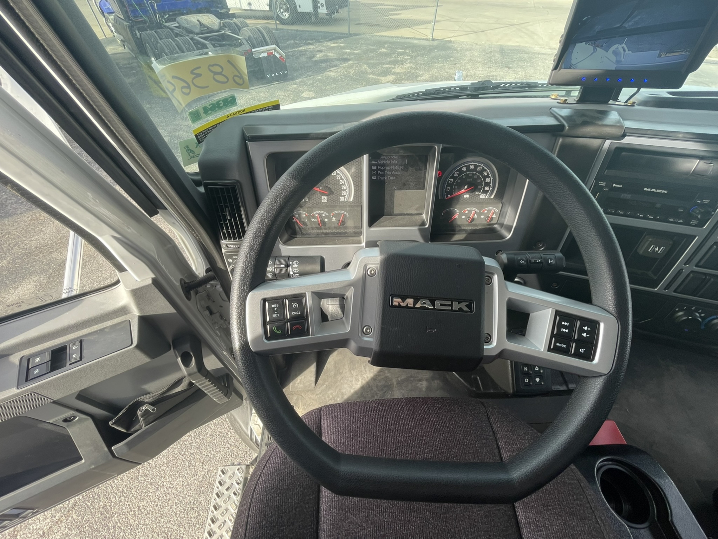 Mack MD7 truck steering wheel and dashboard viewed from driver seat showing Mack emblem and instrument cluster.