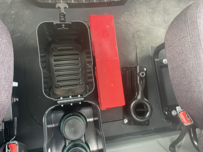 Mack MD7 cabin interior showing center storage box, red toolbox, cup holder, and seat base.