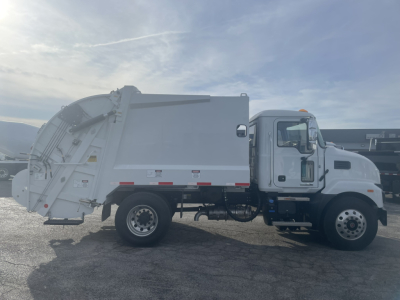 Mack MD7 refuse truck in side profile showing dump bed and cab with VIN 1M2MDBAA1TS077666 on listing.