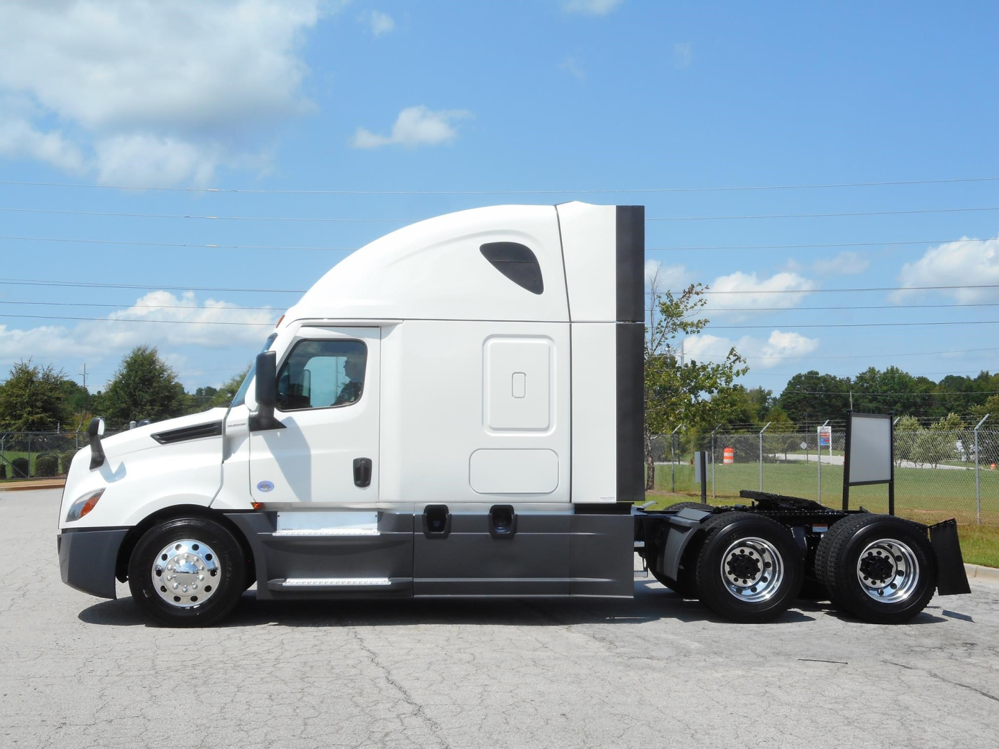 Truck side view of a 2024 Freightliner Cascadia 126 conventional sleeper tractor with white cab and dual rear axles.