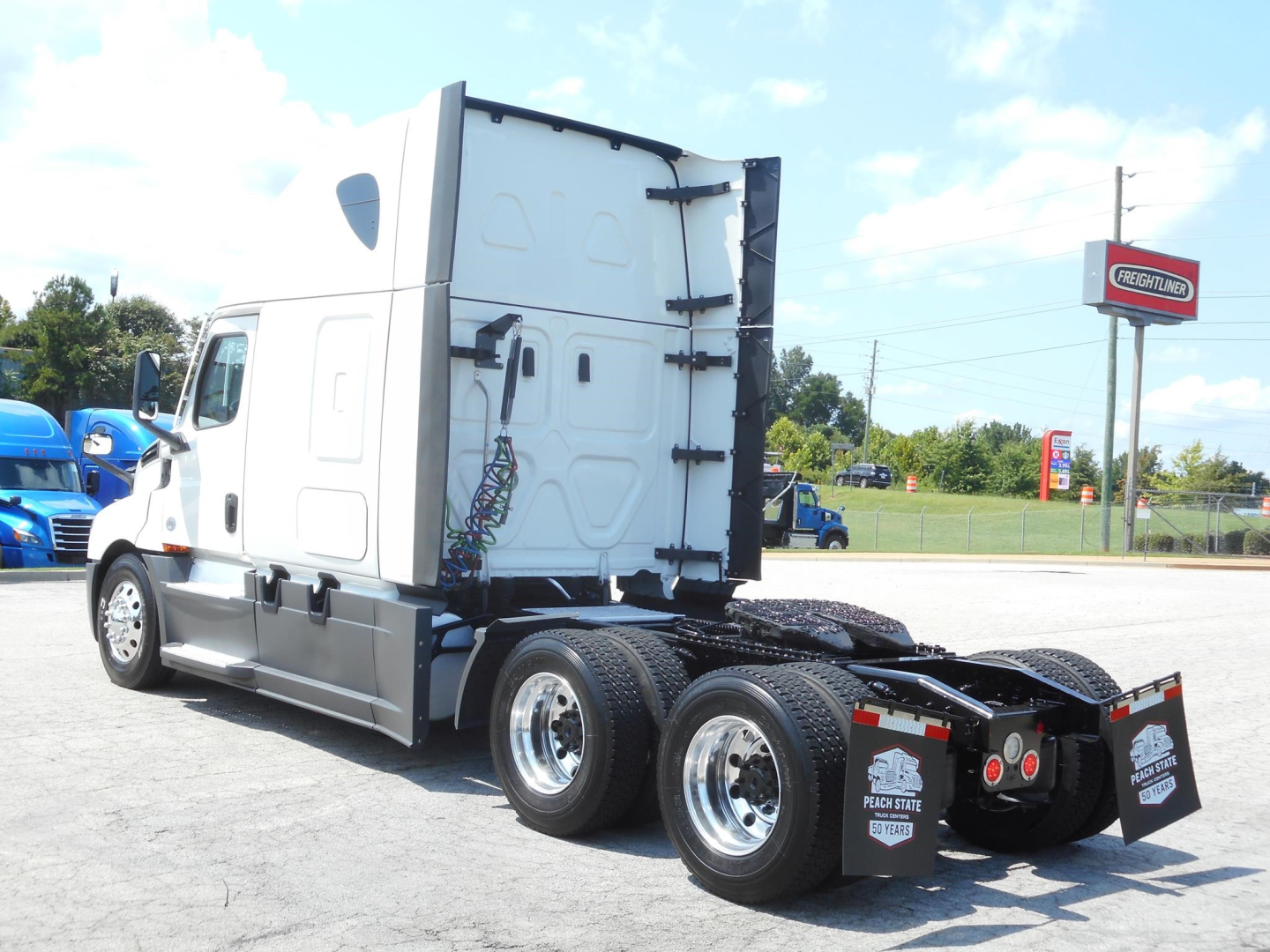 Truck: 2024 Freightliner Cascadia 126 tractor-trailer, side view showing rear axles and fifth wheel, VIN 3AKJHHDR2RSUY6243 visible on listing info.