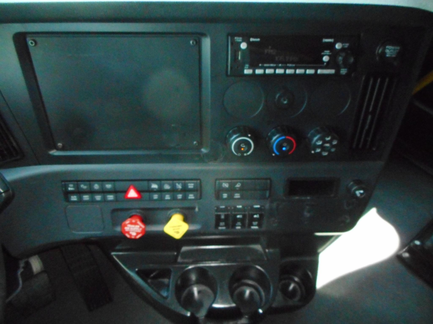 Dashboard of Freightliner Cascadia cab showing control panel, switches, and air conditioning knobs.