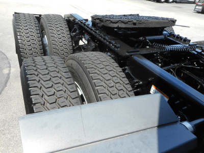 Diesel truck chassis with dual rear axles and heavy-duty tires visible in a Freightliner Cascadia cabless frame.