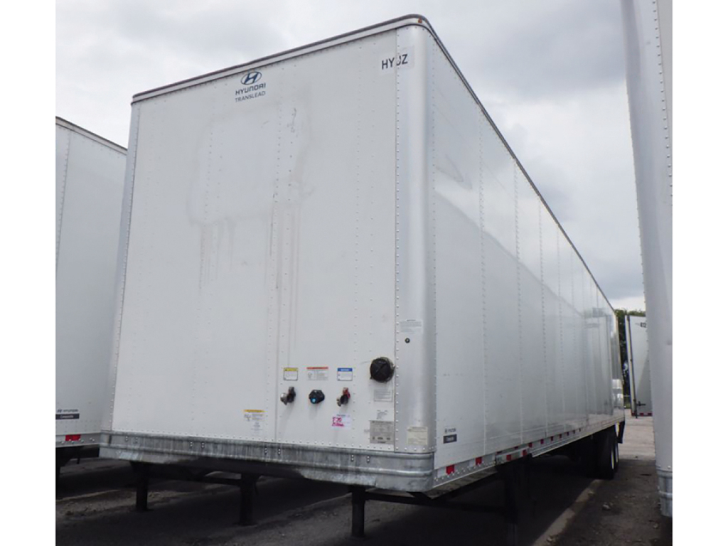 Hyundai HYZ cargo van trailer with a tall rectangular white exterior and rear doors; small control valves and labels near lower rear corner.